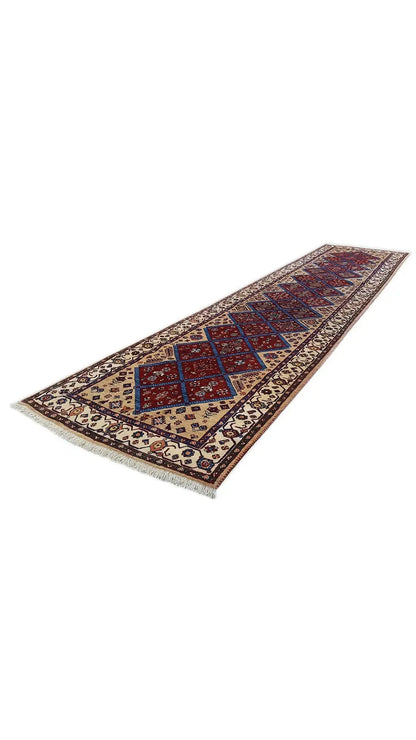Oriental rug, laid lengthwise, with diamond and lozenge motifs in blue and red
