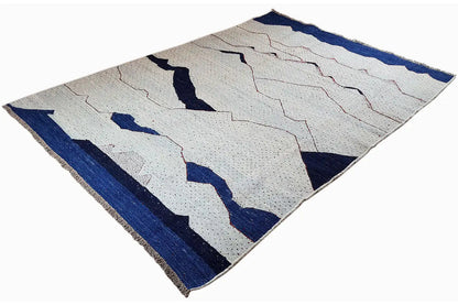 Kilim rug corner with a blue block pattern, red contour lines, and fringes