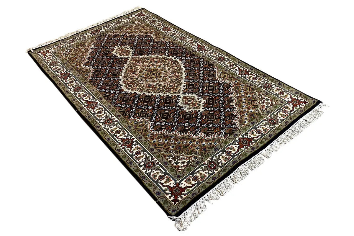 Indo Tabriz rug from an oblique angle, medallion pattern and fringes