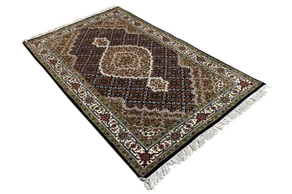 Indo Tabriz rug from an oblique angle, medallion pattern and fringes