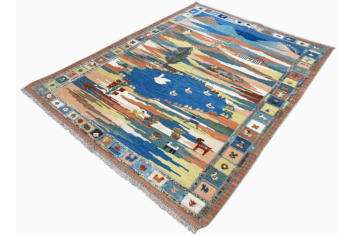 Kilim rug at an angle: landscape scene with birds and multicolored ornamental border