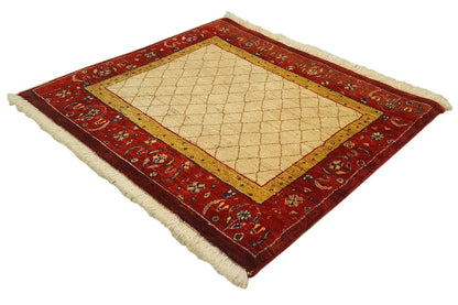 Square rug with a red patterned border and beige center, lying flat.