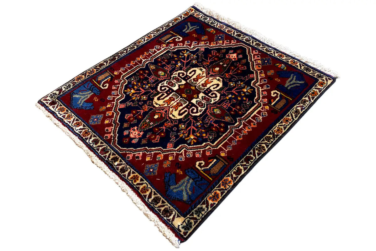 Rug with a geometric diamond design, dark center, and colorful decorative elements