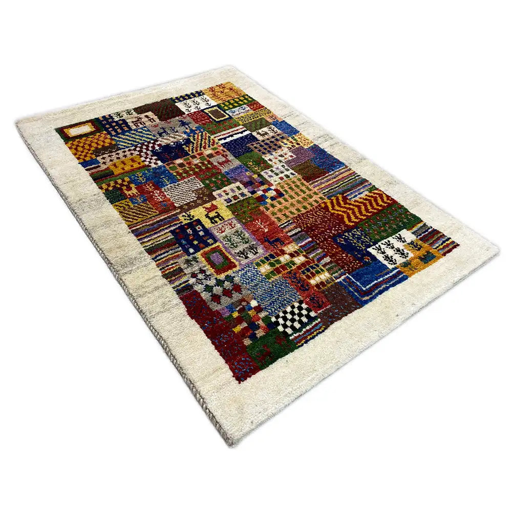 Gabbeh rug, photographed at an angle: multicolored patchwork design with geometric motifs