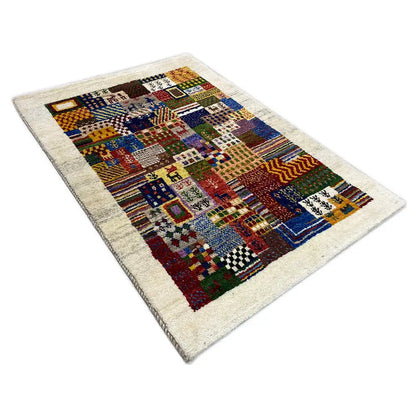 Gabbeh rug, photographed at an angle: multicolored patchwork design with geometric motifs