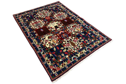 Rug in an angled view: multicolored squares with ornaments and a surrounding border.