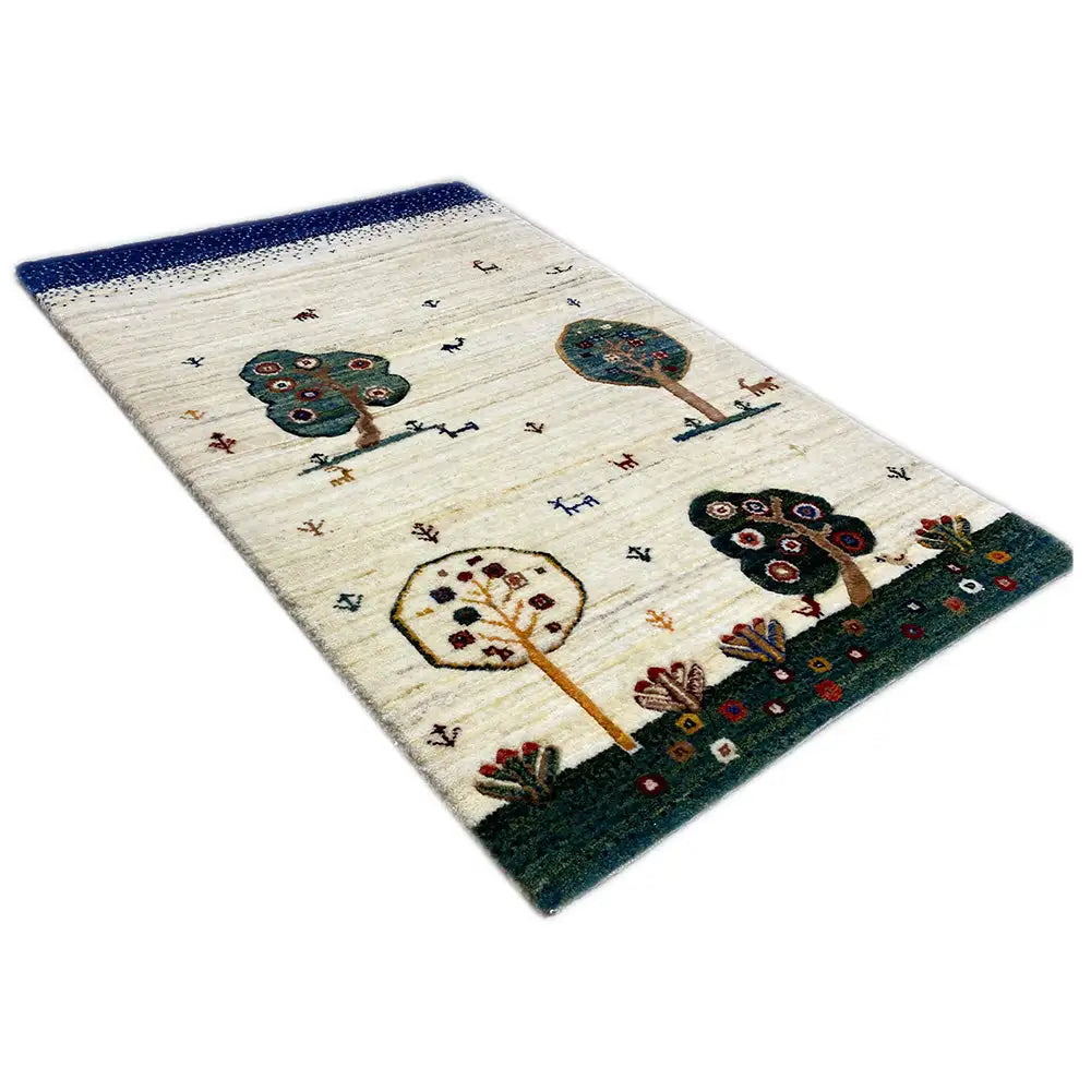 Gabbeh rug with a blue border, cream background, and colorful tree and animal motifs