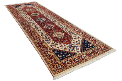 Runner rug with red border design, dark blue field, and fringes along the edges