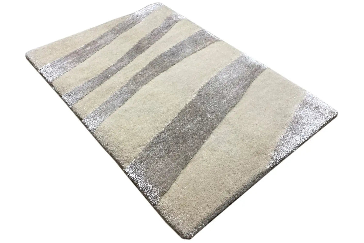 Rug with a beige base and wide gray and light stripes, laid diagonally
