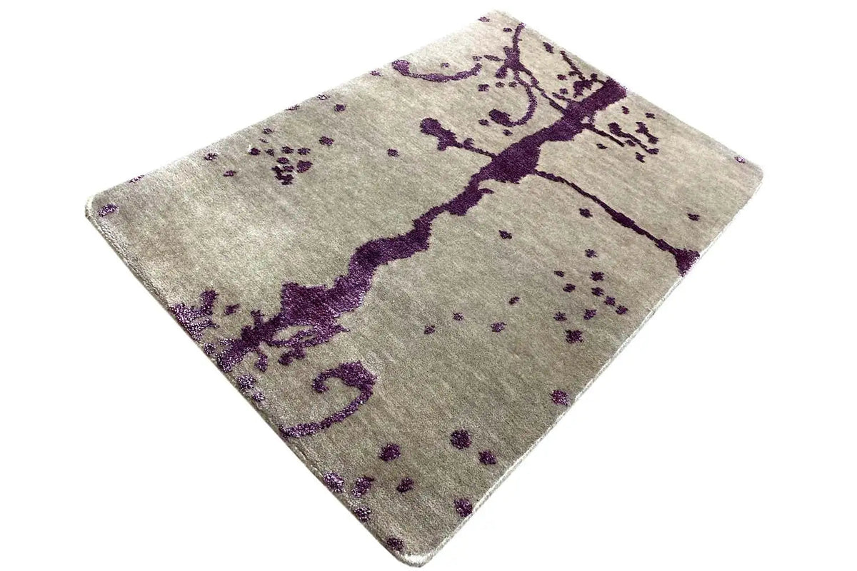 Rectangular designer rug with a purple pattern on a beige background