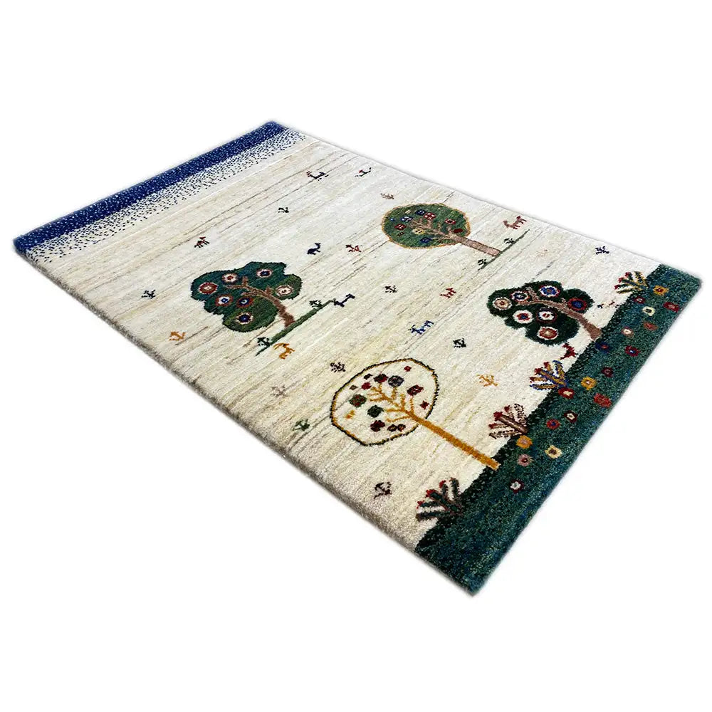 Gabbeh rug with a beige background, two tree and animal motifs; dark green border.
