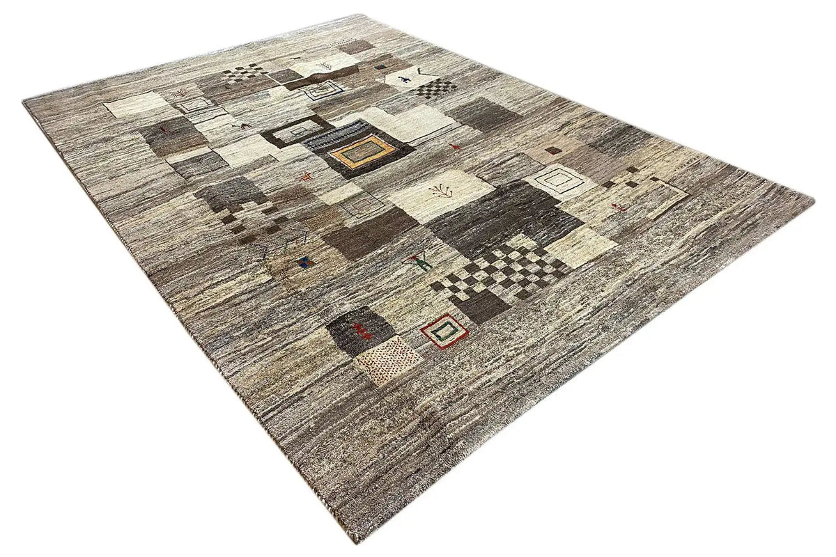 Gabbeh rug in three-quarter view, light patchwork in beige, gray, and dark brown