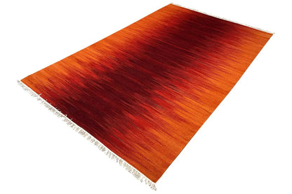 Kilim dhurrie rug, orange-red color gradients, fringe visible at the corner
