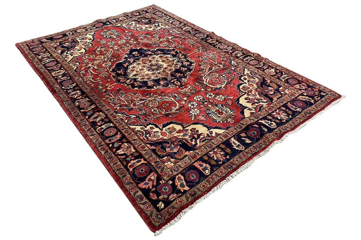 Rug with a red central field and blue ornamental border, central medallion, diagonal view
