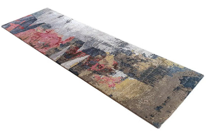 Narrow, elongated rectangular rug with a distressed look and a pattern in shades of gray, blue, and red