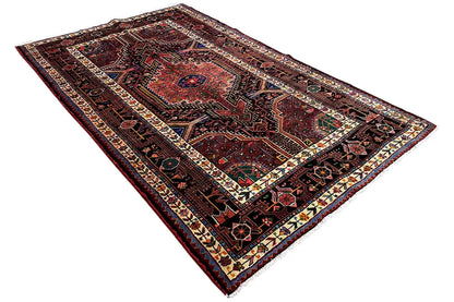 Rug with a central medallion, dark background, and traditional ornamental border