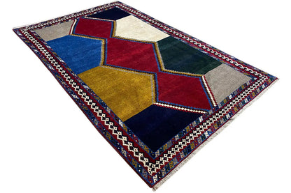 Rug with geometric block diamonds in red, blue, yellow, and beige, with an accentuated border.