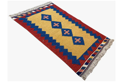 Kilim rug, diagonal view: yellow central stripe, blue ornaments, and red area; fringe