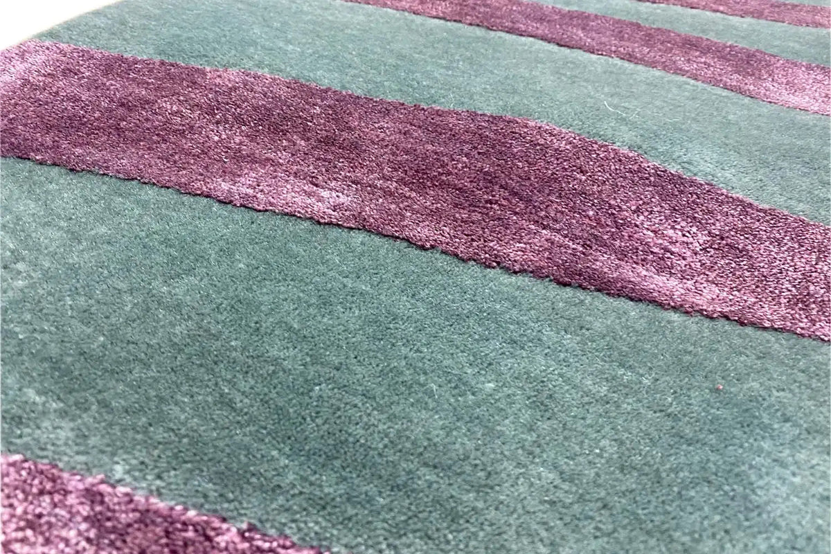 Close-up: teal carpet with purple horizontal stripes and a textured pile