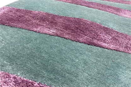 Close-up: teal carpet with purple horizontal stripes and a textured pile