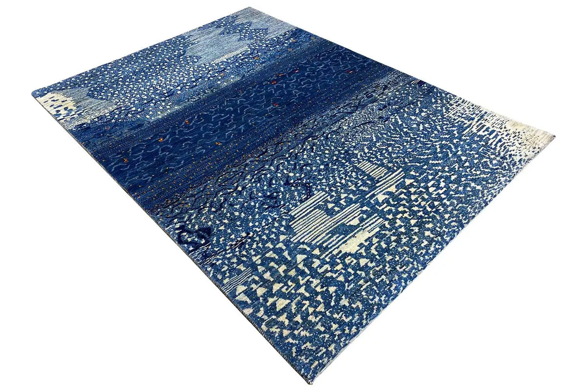 Gabbeh rug with a blue textured background and delicate, light-colored pattern elements