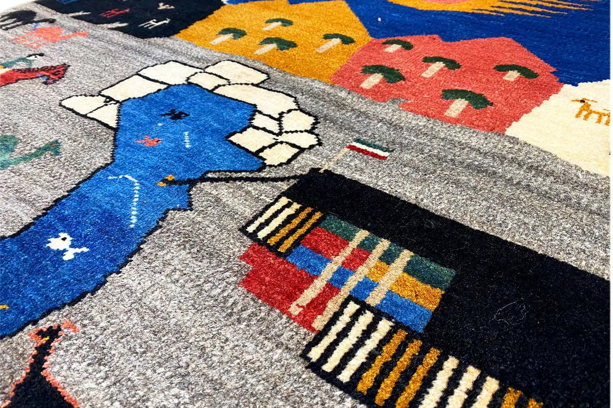 Close-up of a Gabbeh rug: gray field with a blue motif, houses, and borders