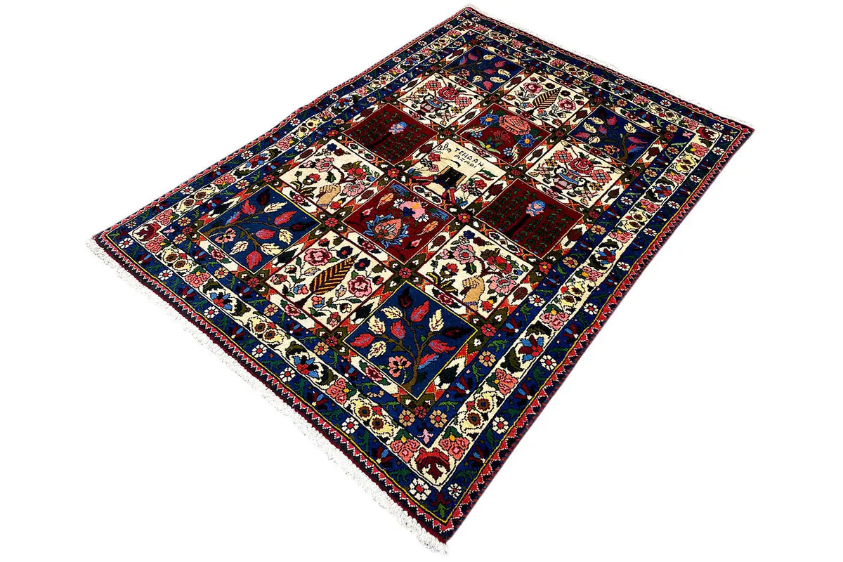 Rug in oblique view: dark blue, red, and beige with tile ornaments and fringes.