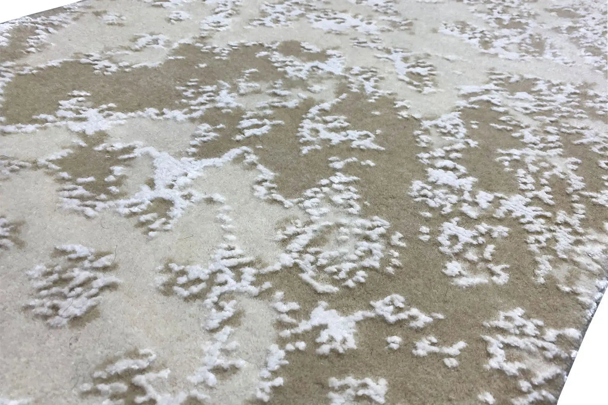 Close-up of designer rug: beige pile with a white, granular textured pattern