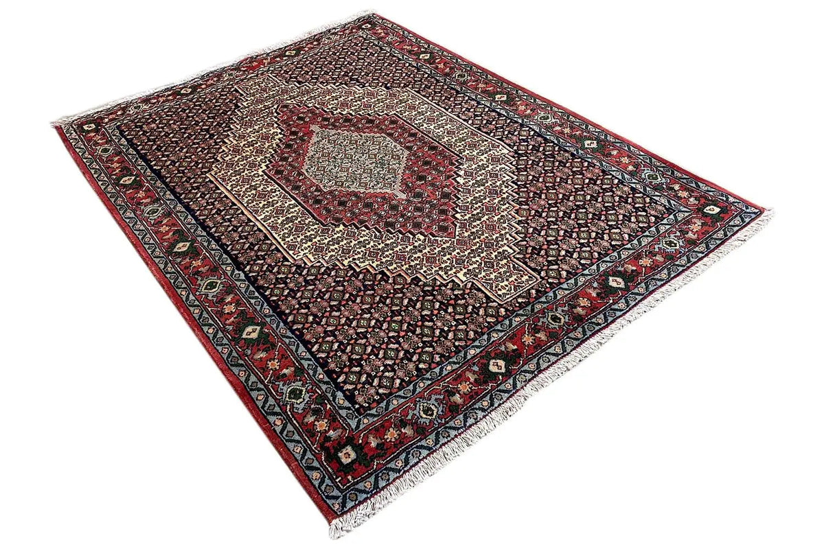 Hamadan rug from above: dark ground weave, red border, and central diamond-shaped field.