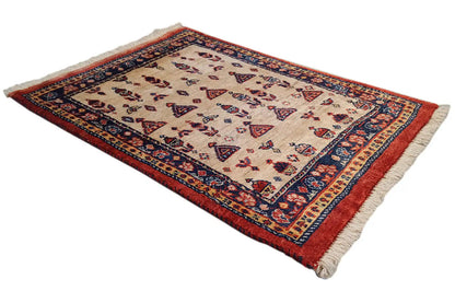 Rug with a beige center, blue medallion border, and red edge, with fringe at one corner