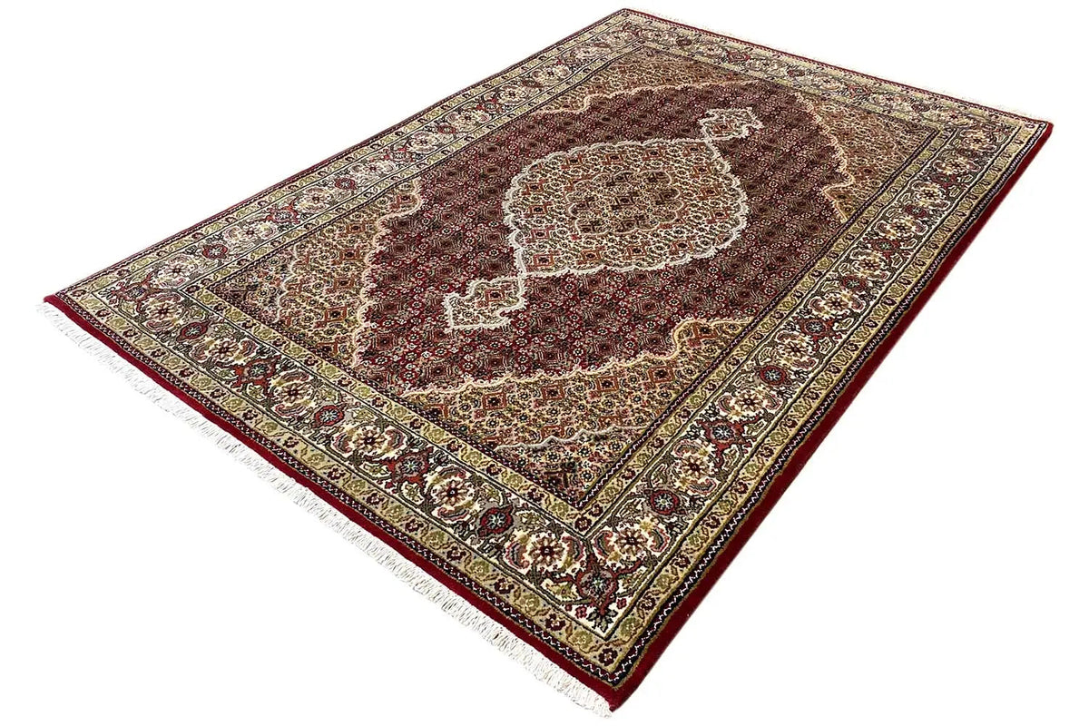 Indo Tabriz rug, shown at an angle: multicolored medallion on a brown background
