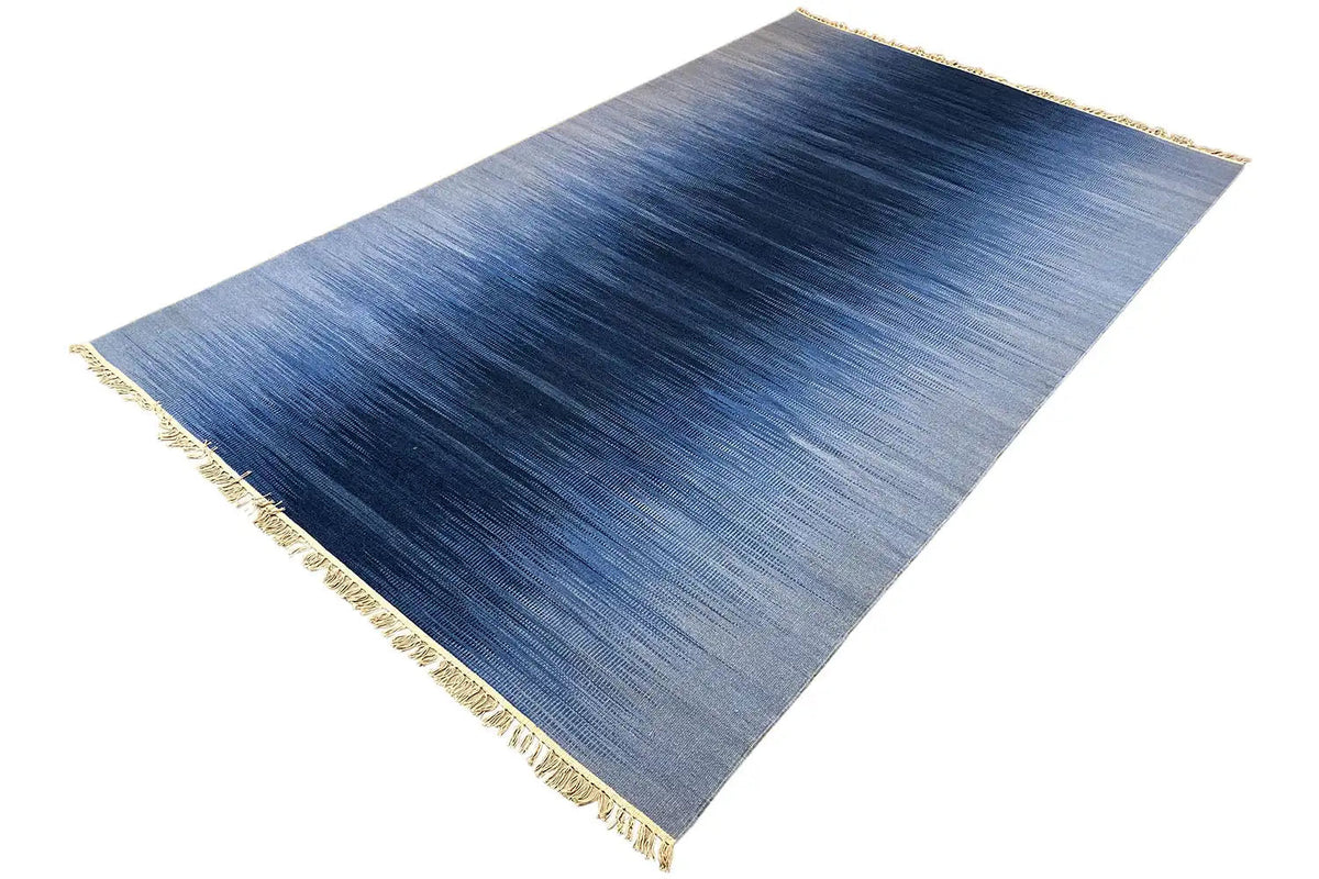 Blue kilim dhurrie rug, flat-weave, clear color gradient in blue, fringes along the edges