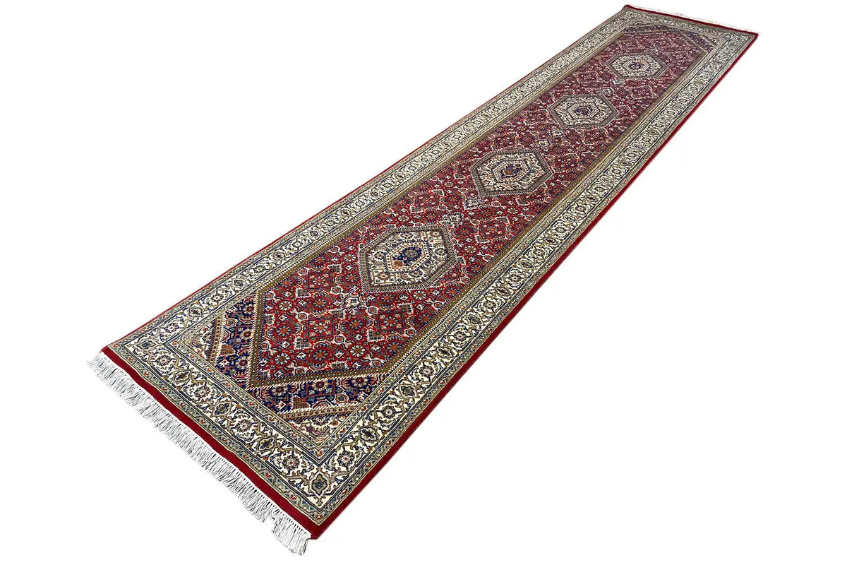 Bidjar runner rug with central medallions in a red pattern and white fringes