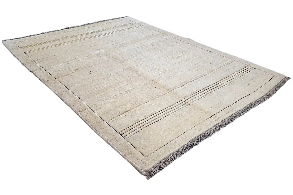 Gabbeh rug in a beige tone with a rectangular border, fine lines, and fringes