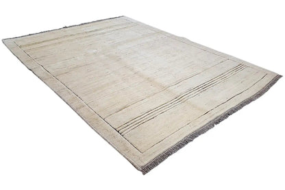 Gabbeh rug in a beige tone with a rectangular border, fine lines, and fringes