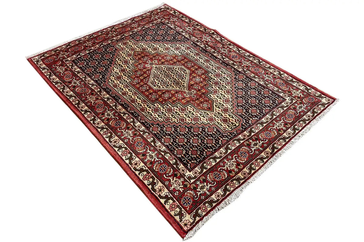 Rug with a red border, dark blue background, and symmetrical ornamental medallion