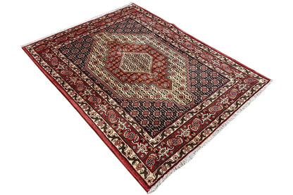 Rug with a red border, dark blue background, and symmetrical ornamental medallion