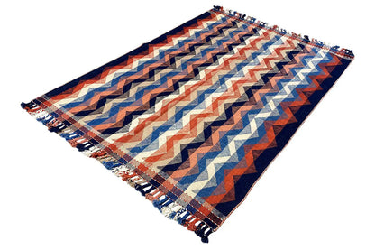 Carpet unfolded with a zigzag pattern, blue-orange accents, and fringes