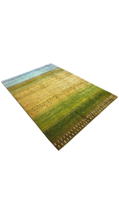 Gabbeh rug in oblique view, yellow-green pattern with a blue border