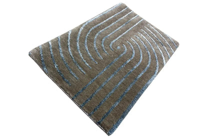 Designer rug with turquoise-blue swirling lines, laid out in a rectangle with rounded corners
