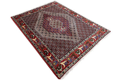 Rug with a central medallion, dark red background, and contrasting decorative border