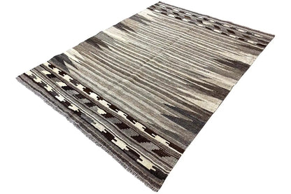 Kilim rug shown at an angle with a high-contrast decorative border