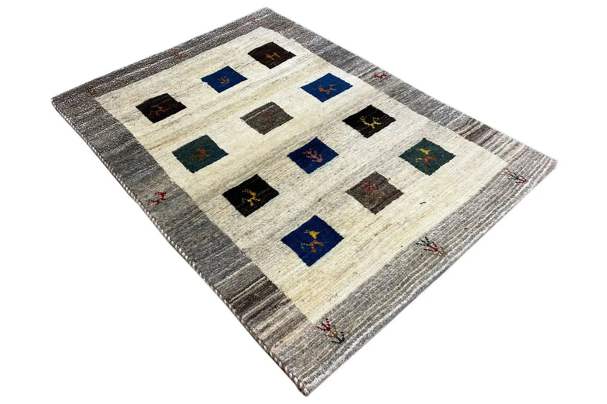 Gabbeh rug with a tile pattern in shades of blue and black on a light cream-colored background