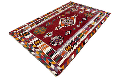 Kilim Qashqai rug, folded view, red background with colorful ornaments and fringes