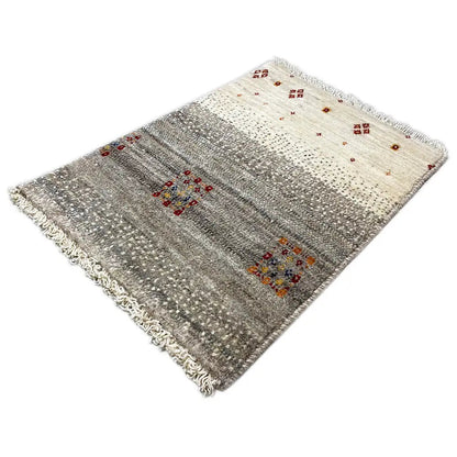 Gabbeh rug with a light beige background, gray areas, colorful square motifs, and fringes