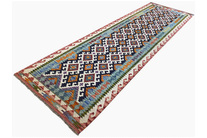 Kilim runner at an angle with a dense central motif, colorful border and border friezes