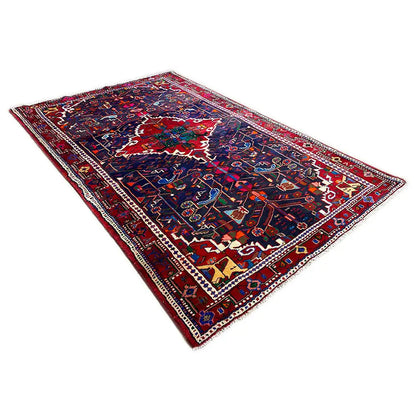 Hamadan rug with a dark background, wide border, and multicolored medallion.