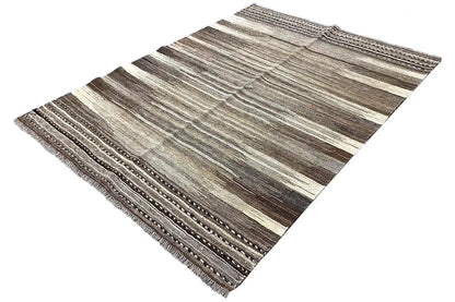 Kilim rug with long light and dark stripes and fringes along the edge