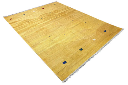 Ochre kilim rug with small blue and red squares, spread out diagonally
