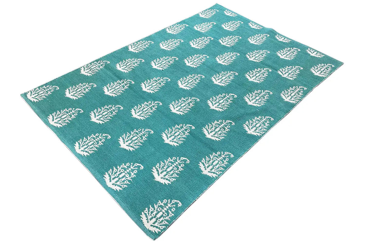 Modern green kilim rug with a white tree pattern, spread out diagonally